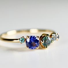 This beautiful sapphire cluster ring was made of 14k solid gold band, 14k gold prong settings. It's perfect as engagement ring or statement piece. DETAILS ABOUT THE RING, MATERIAL AND STONES* 14k 1.3mm solid gold band* 14k solid gold settings* 4.2mm round cut royal blue sapphire* 3.5mm round cut green sapphire* 2.5mm round cut blue sapphire* 2mm round blue sapphire* 2mm round green sapphire We can make this design with any of gemstones. Please contact us. *** All our raw materials are sourced fr Sapphire Cluster Ring, Solid Gold Band, Topaz Jewelry, Tourmaline Jewelry, Aquamarine Jewelry, Garnet Jewelry, Moonstone Jewelry, Green Sapphire, Band Engagement Ring