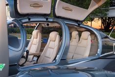 the interior of a car is shown with its doors open and there are also leather seats