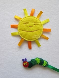 a felt sun and a caterpillar on white paper