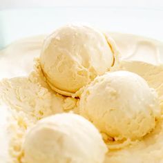 three scoops of vanilla ice cream in a blue square dish on a white surface