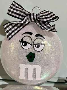 a glass ornament with an m on it