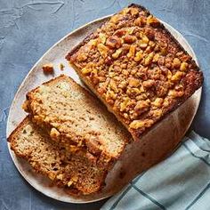 two slices of banana bread on a plate next to a blue towel and a knife