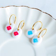 These charming hoop earrings feature dainty white bead polymer clay drops adorned with delicate floral illustrations. The minimalist hoops have a simple yet elegant design that allows the floral accents to take center stage. Ideal for spring and summer events, casual outings, coffee dates or special occasions like Valentine's Day and Mother's Day, they appeal to women and girls of all ages who appreciate fun, feminine accessories. Lightweight and versatile, these earrings make thoughtful novelty White Hypoallergenic Small Hoop Earrings, White Dangle Earrings With Lever Back, White Polymer Clay Flower Earrings For Everyday Wear, Everyday White Flower Earrings In Polymer Clay, Dainty White Hypoallergenic Hoop Earrings, Dainty White Nickel-free Hoop Earrings, Adjustable White Hoop Earrings With Ear Wire, Everyday White Polymer Clay Flower Earrings, White Small Hoop Hypoallergenic Earrings