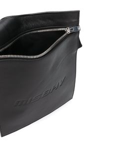 Black lether embossed logo envelope shoulder bag from MISBHV featuring a shoulder strap, a top zip closure, a front embossed logo stamp and silver-tone hardware. | Misbhv Embossed Logo Envelope Shoulder Bag Formal Crossbody Shoulder Bag With Embossed Logo, Evening Leather Bag With Embossed Logo, Modern Crossbody Bag With Embossed Logo, Formal Shoulder Bag With Embossed Logo, Modern Evening Shoulder Bag With Embossed Logo, Classic Leather Shoulder Bag With Embossed Logo, Leather Shoulder Bag With Logo For Business, Business Leather Shoulder Bag With Logo, Leather Business Shoulder Bag With Logo