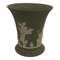 a green vase with white designs on it