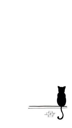 a black cat sitting on top of a white wall