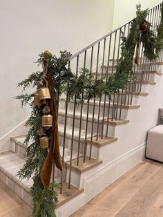 a staircase decorated with christmas garland and bells