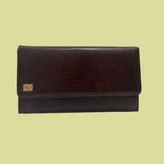 "Vintage Ande brown leather clutch bag, manufactured ca. 1970s. Rectangular shape with gold toned hardware and an \"LA\" logo on the front left. Bag has a location to connect a strap if interested.    - Brand: Ande    - Measurements: 10.5\" x 2.5\" x 6\"\"     - Time Period: 1970s    - Color(s): Brown leather (unsure if faux or real)    - Condition: The bag is in excellent condition with just a bit of wear on the internal lining (see final photo).  This item has 100% FREE United States domestic Luxury Brown Envelope Clutch, Vintage Brown Rectangular Evening Bag, Classic Brown Evening Bag For Formal Occasions, Classic Brown Formal Evening Bag, Formal Brown Envelope Bag, Retro Brown Clutch For Evening, Vintage Brown Wallet For Formal Occasions, Vintage Brown Wallets For Formal Occasions, Brown Rectangular Wallet For Evening