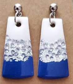 These handmade polymer clay dangle earrings feature a dazzling blue, white and silver color combination. Their intricate design is perfect for adding a touch of chic sophistication to any look. Each earring is lightweight and comfortable, allowing for all-day wear.  Hypoallergenic. Handmade White Resin Earrings, White Dangle Earrings In Polymer Clay, Silver Dangle Earrings In Polymer Clay, White Polymer Clay Dangle Earrings, Nickel Free Silver Polymer Clay Earrings, Clay Dangle Earrings, Sun City, Intricate Design, Handmade Polymer Clay