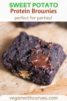 two brownies with chocolate frosting sitting on top of a wooden cutting board