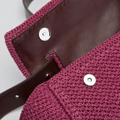 a close up of a handbag on a white surface with a brown leather strap