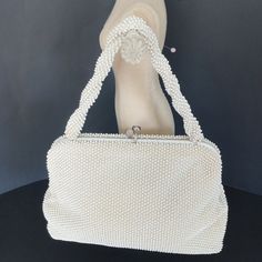 "Classic 1950s Large Corde Beaded Handbag with 2 large storage compartments and Silver Top Kiss Clasp.  The style is Mid Century Modern / Hollywood Regency.  The design is Mini Beads all over with the handle having a special Twist.  The inside is a cream white linene.  There is a business card size pocket on the inside. The top has a white acrylic bar that opens the bag and holds the silver kiss clasp.  Everything works well on this purse. Corde Large Handbag by Lumured from 1950s This special l Classic White Wedding Bag, Vintage Cream Bags For Weddings, Vintage Cream Bag For Wedding, Vintage Rectangular Wedding Bags, Vintage Formal Bag With Pearl Embroidery, Vintage Formal Bags With Pearl Embroidery, Vintage Cream Evening Bag For Wedding, Vintage Beaded Evening Bag For Wedding, Vintage Beige Evening Bag For Wedding