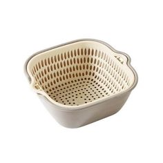 a white ceramic colander with holes in the bottom and sides on a white background