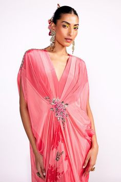 Flamingo pink draped kaftan with floral print, highlighted with floral embroidery on the waistband.
Components: 1
Pattern: Print, Embroidery
Type Of Work: Floral
Neckline: V Neck
Sleeve Type: Split Sleeves
Fabric: Crepe, Lining: Crepe
Color: Pink
Other Details: 

Model height: 5ft 8 inches, wearing size S
Note: Hair accessory worn by the model is not for sale
Occasion: Resort - Aza Fashions Floral Embroidered Kaftan With Traditional Drape For Party, Floral Embroidered Kaftan For Party, Party Kaftan With Floral Embroidery And Traditional Drape, Evening Kaftan With Floral Embroidery, Pink Designer Dress With Cape Sleeves, Designer Pink Dress With Cape Sleeves, Festive Pink Dress With Cape Sleeves, Pink Traditional Drape Dress For Spring, Traditional Pink Dress For Spring