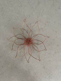 a metal flower on top of a white table