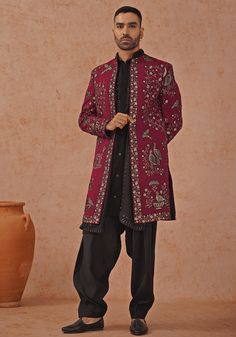 Elevate your style with Wine embroidered sherwani. Crafted from georgette, the sherwani showcases intricate cut dana, Swarovski, and pearl handwork. The handwork collar detailing adds an extra touch of elegance. Paired with a black kurta featuring embroidered yoke design, front hook closure, two pockets, and pure lining. Completed with patiyala pants and dupatta. Perfect for special occasions like Sangeet, Mehendi, or as a wedding guest outfit. Composition : Sherwani, Kurta, Patiyala Pant & Dupatta : Viscose Georgette Care: Dry Clean Only and Vacuum Storage This product can be customized for sleeves, length and colour Delivery : 4-6 weeks as the product is hand crafted. Check Size Guide or choose MySize for free customisation (All Sizes above XL can be made at 15% additional cost) For more Semi-stitched Silk Sherwani With Resham Embroidery, Semi-stitched Silk Sherwani Straight Kurta, Designer Silk Sherwani With Traditional Drape, Silk Sherwani With Dabka Straight Kurta, Traditional Silk Sherwani With Mirror Work, Designer Silk Sherwani Straight Kurta, Silk Sherwani With Traditional Drape For Ceremonial Occasions, Bollywood Style Silk Sherwani With Dabka Work, Semi-stitched Silk Sherwani For Designer Wear