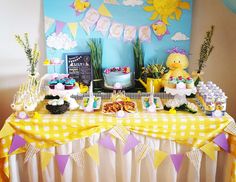 a table topped with cakes and desserts covered in yellow and white checkered paper