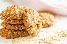 three oatmeal cookies stacked on top of each other next to a pile of oats