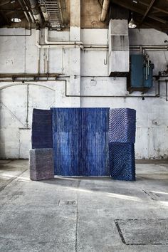 three blue pieces of art in an industrial building