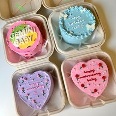 four heart shaped birthday cakes in plastic containers