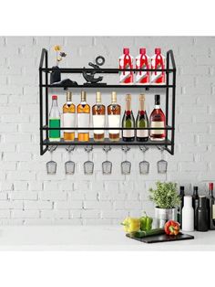 a shelf filled with bottles and glasses on top of a white counter next to a brick wall