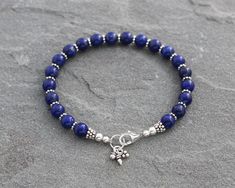 All natural vibrant blue Lapis Lazuli beads are paired with Bali style Turkish sterling silver accents and finished with a secure sterling silver lobster clasp in this bracelet. I also added a few coordinating sterling silver charms for an extra accent. Perfect to wear by itself or with other bracelets for a stacked look. Sterling silver is .925 pure silver. Bali silver is .925 pure silver. Turkish silver is .925 pure silver. See more Lapis Lazuli jewelry here: https://www.etsy.com/shop/LindseyS Blue Beaded Bracelets With Sterling Silver Gemstone Beads, Spiritual Beaded Bracelets With Sterling Silver Clasp, Adjustable Blue Beaded Bracelet With Sterling Silver Clasp, Blue Beaded Bracelets With Sterling Silver Clasp, Blue Sterling Silver Bracelet With Round Beads As Gift, Lapis Lazuli Jewelry, Bali Style, Bali Silver, Lapis Lazuli Beads