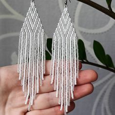 "White beaded earrings Seed bead earrings White silver chandelier earrings Shiny earrings Boho Evening earrings Length, beadwork part - 12.5 Centimeters (4.92\") Width -  3 Centimeters (1.18\") Materials: Czech glass beads Nylon Thread Silicone plugs  Stainless steel ear hooks .. ready to be given away! Contact me if you have any questions. I will be happy to answer :) Please note that due to lighting effects, monitor's brightness, contrast and other settings, there might be some slight differences in the color tone/shade of the web site's photo and the actual item. SHOP POLICY 1. If the package is damaged or your post tries to deliver you an empty package, refuse to receive it or file a claim, otherwise it can't be proven. 2. International customers are responsible for any import fees, ta Elegant Silver Earrings With Colorful Beads, Elegant Silver Dangling Beads, Elegant Silver Beaded Chain Earrings, Silver Beaded Chain Earrings, Silver Chandelier Earrings With Colorful Beads, Silver Chandelier Earrings With Faceted Beads, Elegant White Chandelier Earrings With Colorful Beads, Elegant White Beaded Chain Earrings, White Dangle Earrings With Faceted Beads