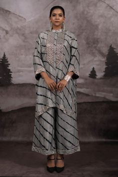 Silver and grey three fourth sleeves asymmetric band collar kurta with all over black toned leheriya wave tie dye pattern and hand embroidery using silver toned zardozi, pitta, nakshi highlights. Paired with a matching palazzo pant and a scarf. - Aza Fashions Designer Gray Set With Zari Work, Festive Gray Zari Work Sets, Gray Anarkali Set With Dupatta, Gray Anarkali Set For Festive Occasions, Gray Festive Sets With Resham Embroidery, Festive Gray Diwali Outfit Sets, Festive Gray Sets With Dupatta, Gray Festive Sets For Diwali, Festive Gray Sets For Eid