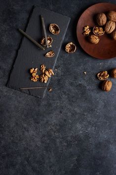 walnuts are on a plate next to an empty notebook