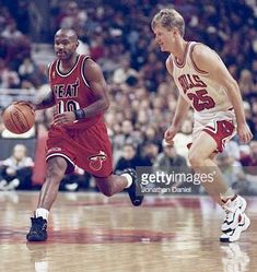 two basketball players in action on the court during a game with an audience watching them