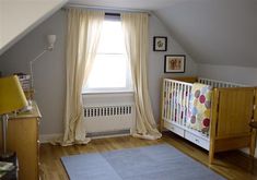 a baby's room with a crib, dresser and window