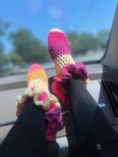 someone is wearing crocheted slippers while sitting in the car