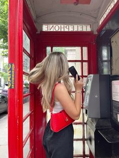 a woman standing in front of a phone booth