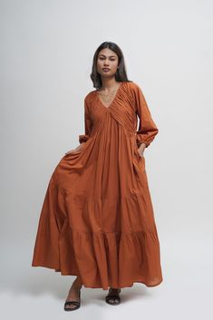 Experience freedom in our loose, tiered boho dress made from 100% organic cotton.  The V-neck combined with the tiered skirt and intricate pleated detailing makes it perfect for beach strolls and summer dinners.  Features two inseam pockets and customizable colour options.  Length: 51 inches.  Quality: 60's Organic Cotton.  Care: Hand wash with light detergent or dry clean.  Ships within 3-5 business days. For quicker delivery please send us a message. Additional Information: Colour: Burnt toffe Lehnga Dress, Cotton Maxi Dress, Western Outfits Women, Layered Dress, Beige Dresses, Boho Tunics, Cotton Maxi, Maxi Dress Cotton, Dress Boho