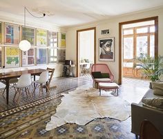 a living room filled with furniture and pictures on the wall next to a dining table