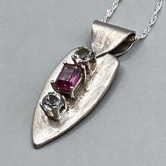 "HANDMADE OOAK PENDANT Sterling Silver with a Garnet center stone flanked by a pair of Green Amethysts from Africa. The Garnet is an emerald cut 6mm x 4mm. The Green Amethysts are round cut 4mm gemstones. The pendant is 1/2\" wide and 1 1/4\" long including the bail. The necklace is 18\" long. If this inspires you, but isn't quite what you want, DM me - I love working with customers to create the jewelry piece of their dreams!" Amethyst Multi-stone Necklace For Anniversary, Multi-stone Amethyst Necklace For Anniversary, Multi-stone Amethyst Pendant Jewelry, Amethyst Multi-stone Pendant Jewelry, Green Amethyst, Sterling Silver Pendant, Emerald Cut, Dm Me, Sterling Silver Pendants