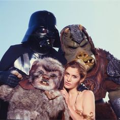 a woman standing next to two star wars characters