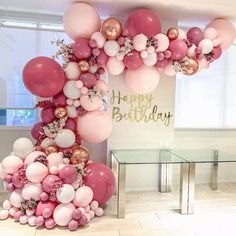 a bunch of balloons that are in the shape of a birthday arch with pink, white and gold balloons