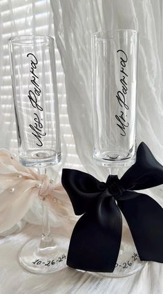 two wine glasses with black bows on them