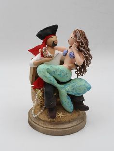 a figurine of a man and woman sitting on top of each other,