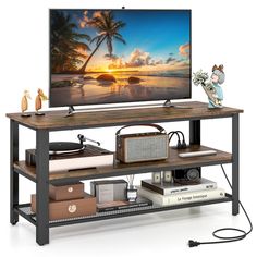 With its 43.5"L x 16.5"W spacious countertop, this TV stand accommodates screen TVs up to 50 inches and provides ample space for electronics. Featuring 2 storage shelves for media devices, books, or decorations, it keeps everything organized. Equipped with a built-in recessed power outlet including 2 AC outlets, 2 USB A ports, and a USB C port, it ensures easy charging. The sturdy metal frame supports up to 340 lbs, and adjustable foot pads offer stability on any surface. Its versatile industria 3 Shelf Bookcase Tv Stand, Vintage Tv Stand Target, Industrial Tv Cabinet, Tv Stand Industrial Pipe, Industrial Bookshelf Tv Stand, Tv Stand Bookshelf Rustic, Rustic Tv Console, Industrial Sofa Table, Target Tv Stand