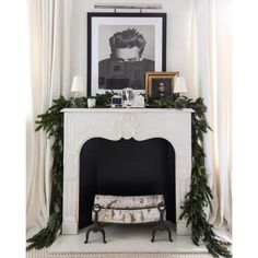 a fireplace decorated for christmas with greenery