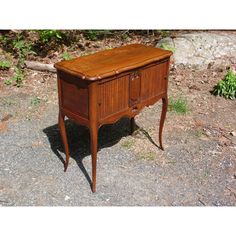 an old wooden desk sitting on the ground