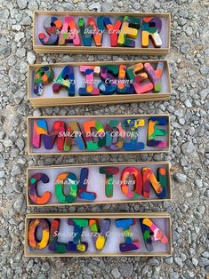 three boxes filled with different colored letters on top of a gravel covered ground next to each other