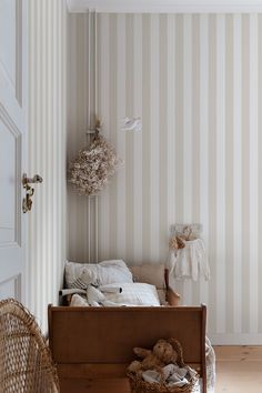 a bedroom with striped wallpaper and wooden flooring