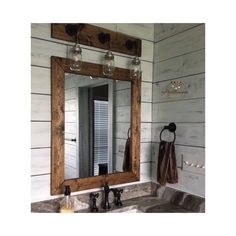 a bathroom sink sitting under a mirror next to a wooden counter top with soap dispensers on it