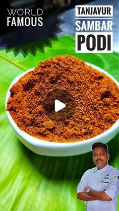 a man standing in front of a bowl filled with red powder on top of a green leaf