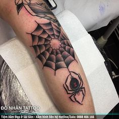 a man with a spider tattoo on his leg and the arm is covered in black ink