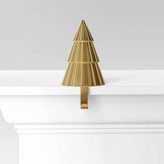 a gold christmas tree on top of a white mantle