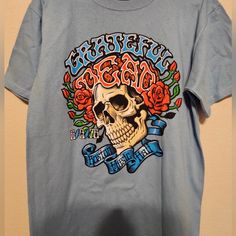 Size Medium Grateful Dead Band Tee Music Shirt Rock And Roll Skulls And Roses Brand New Blue Screen Print T-shirt For Concert, Blue Band Merch T-shirt, Blue Skull Print Crew Neck Top, Casual Blue T-shirt With Skull Print, Blue Short Sleeve Tops With Skull Print, Casual Blue Tops With Skull Print, Blue Skull Print Tops For Summer, Blue Cotton T-shirt For Concert, Blue T-shirt For Summer Concerts